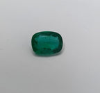 Cushion-shaped emerald on a light gray background
